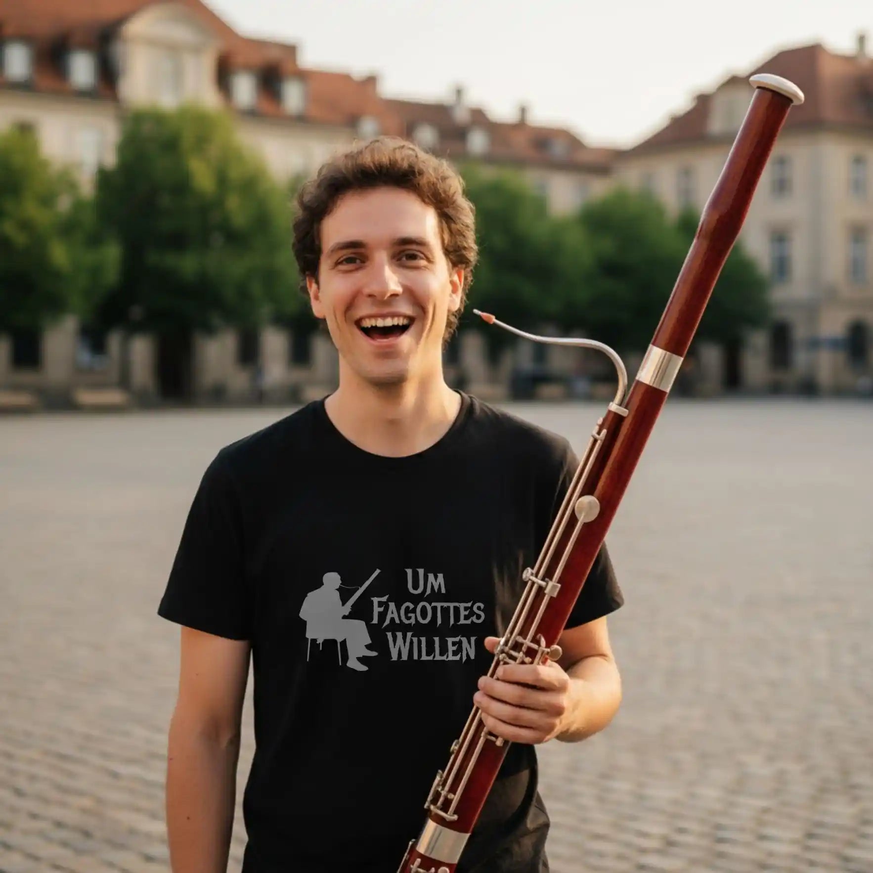 Fagottist mit T‑Shirt „Um Fagottes Willen“ vor historischem Haus
