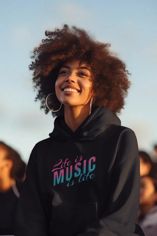 Schwarzer Hoodie mit farbigem „Life is Music“-Motiv, getragen von einer lächelnden Frau.