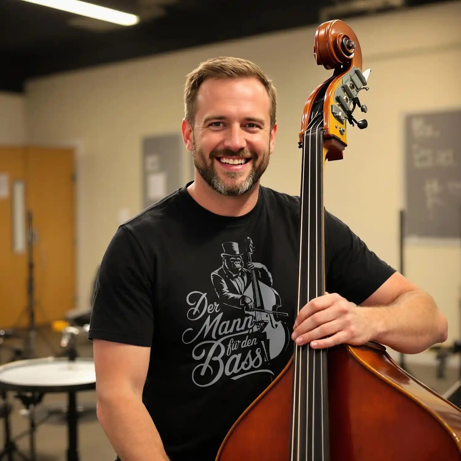 Mann mit Kontrabass und T‑Shirt „Der Mann für den Bass“ Gorilla‑Motiv