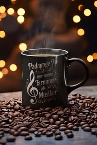 Schwarze Tasse mit personalisierbarem Musikmotiv und frei wählbarer Berufsbezeichnung, hier gezeigt am Beispiel „Pädagoge“.