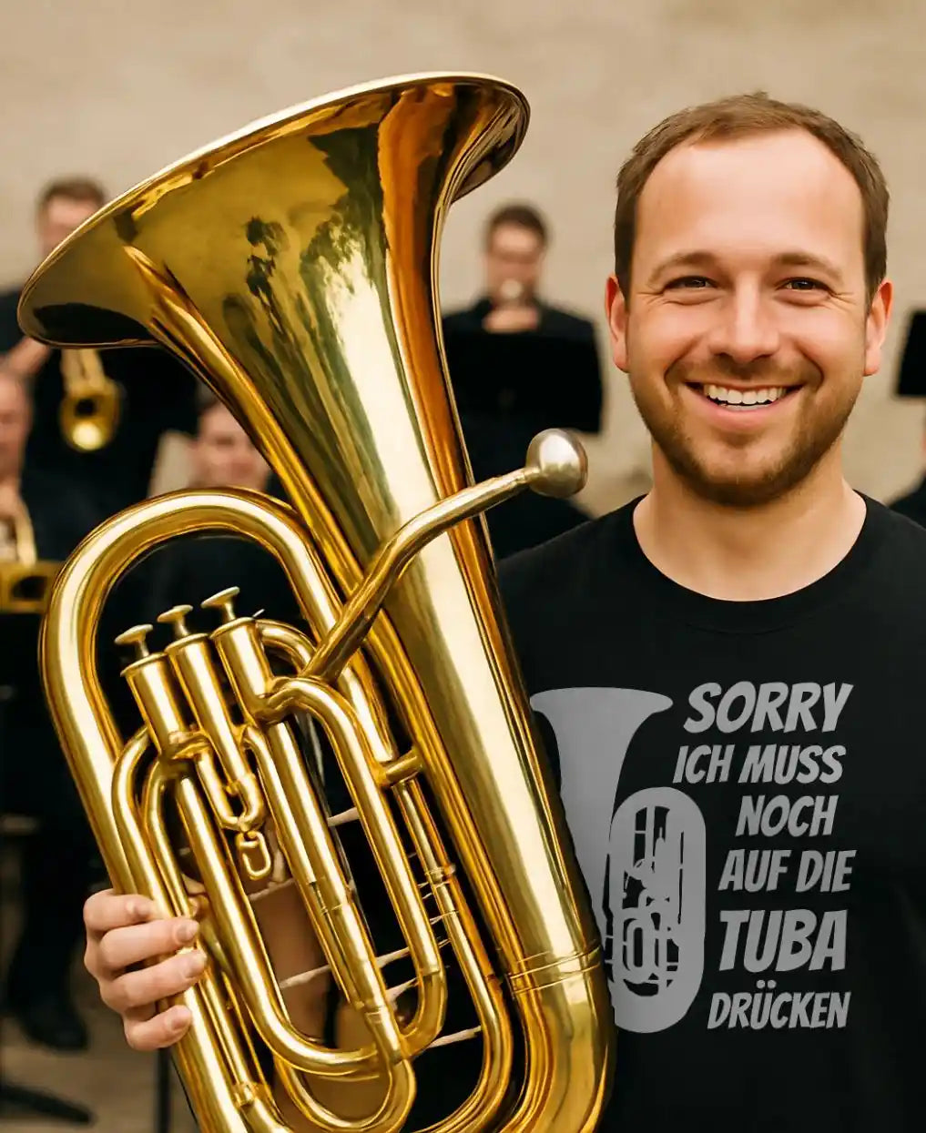 Lachender Tubist mit Tuba und Shirt „Sorry ich muss noch auf die Tuba drücken“
