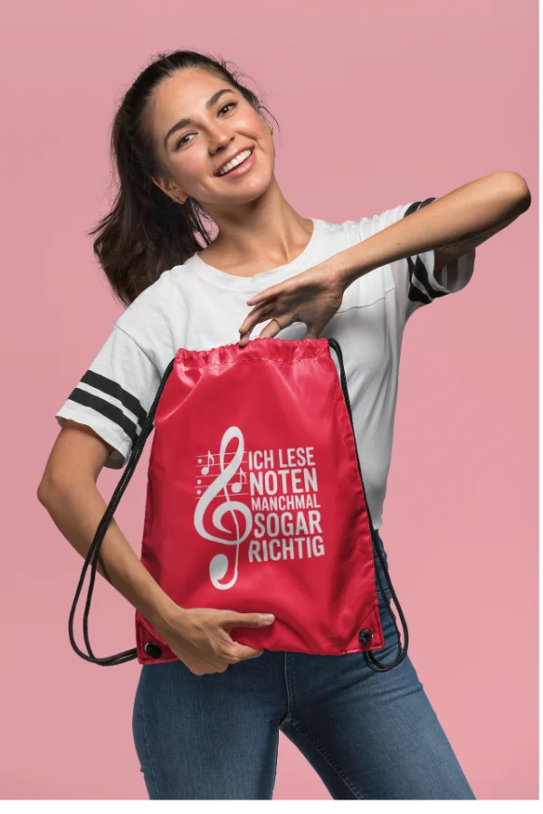 Roter Turnbeutel mit dem Musikerspruch „Ich lese Noten manchmal sogar richtig“, getragen von einer Frau.