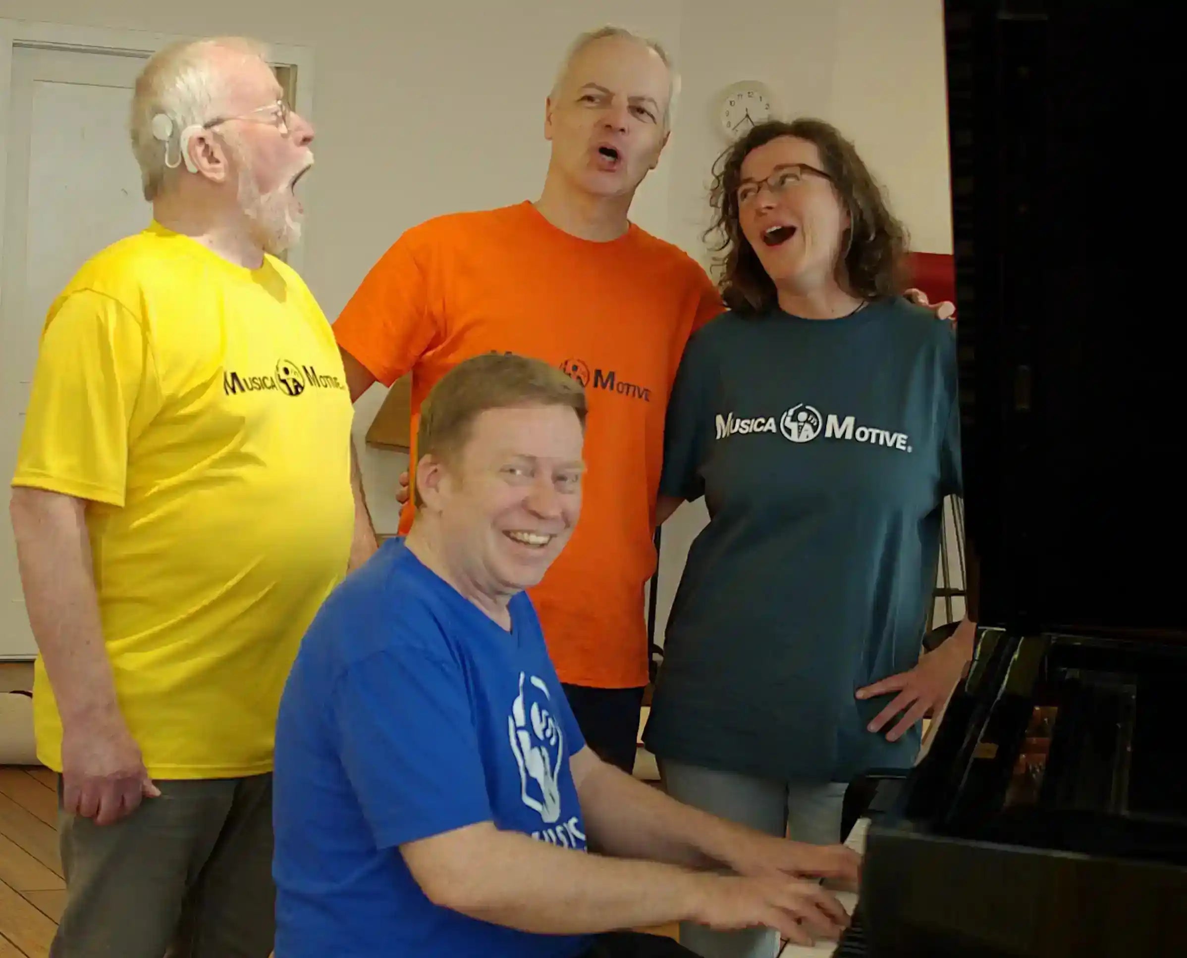Das MusicaMotive-Team beim gemeinsamen Singen im Musikraum am Klavier.